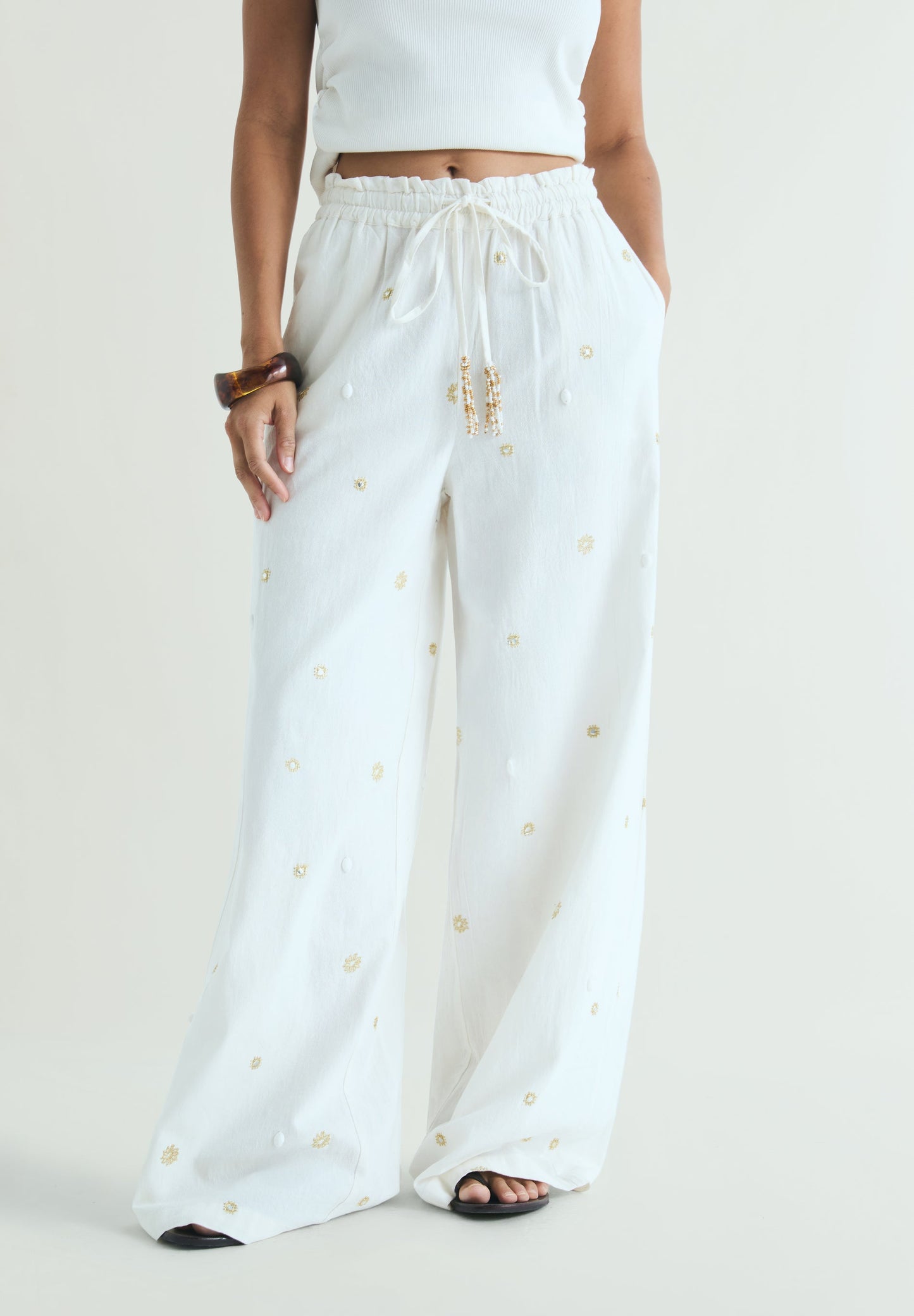 TROUSERS WITH METALLIC DETAILS