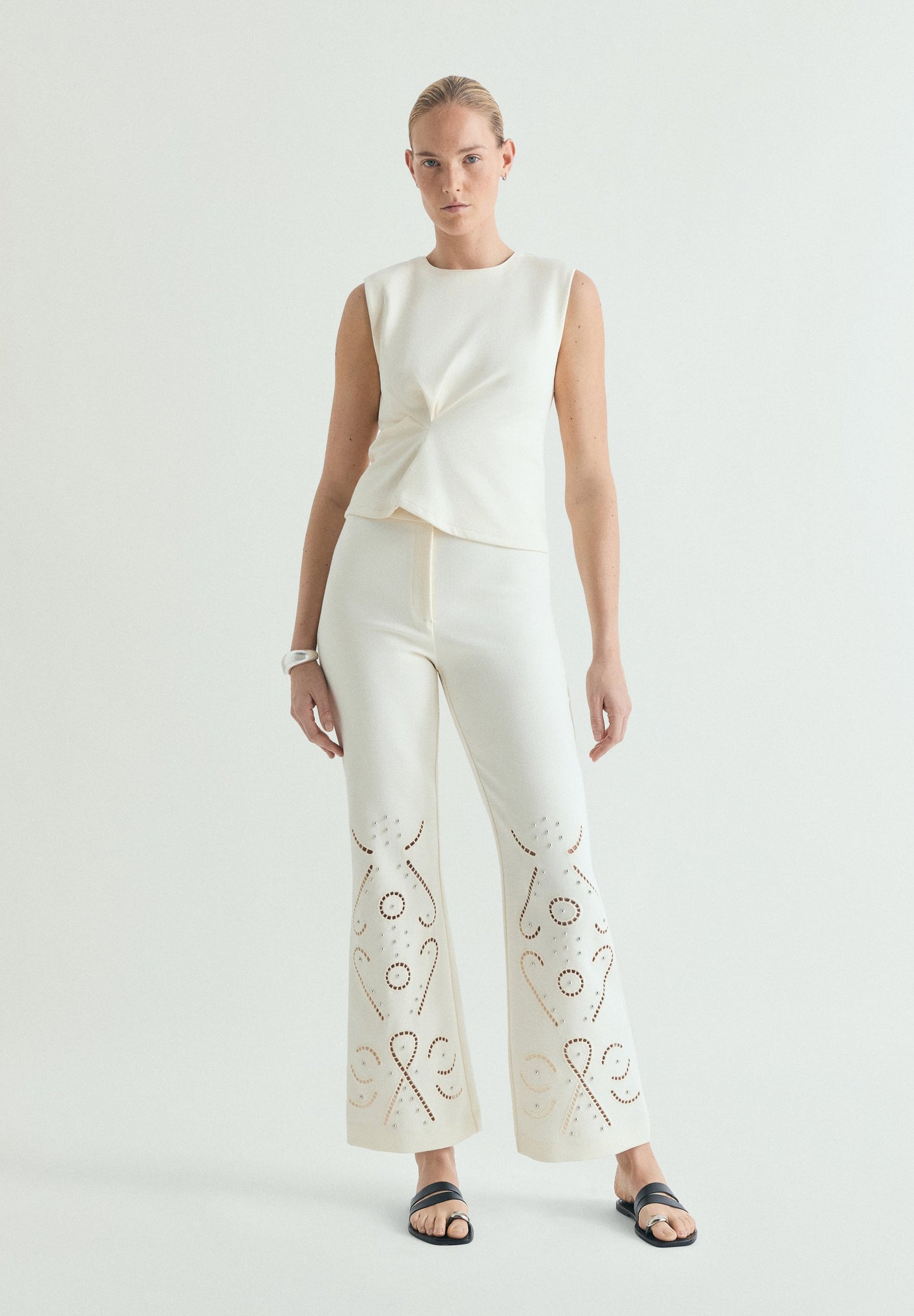 TROUSERS WITH PERFORATED DETAILS